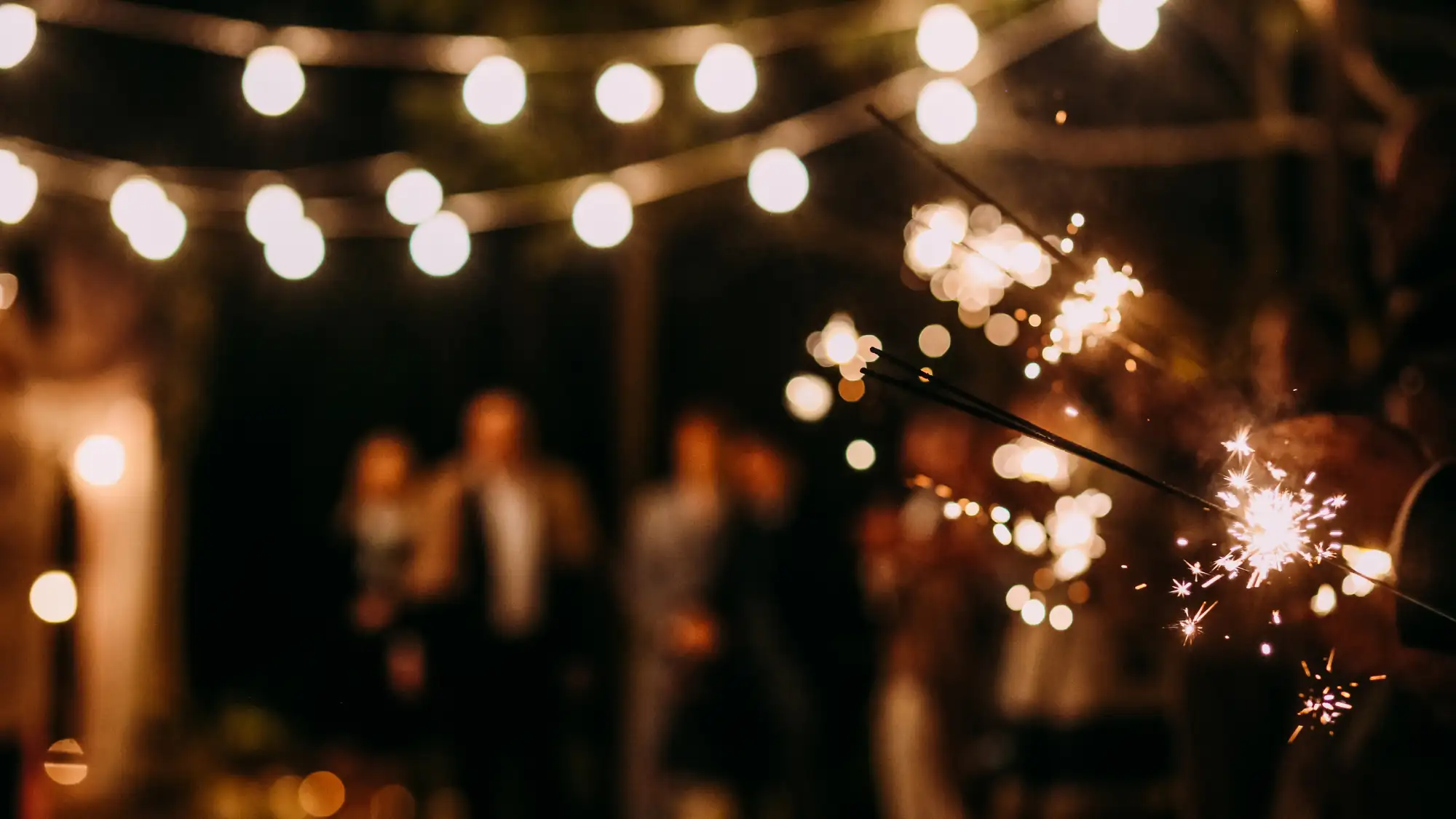 A small outdoor wedding with intimate lighting and sparklers.