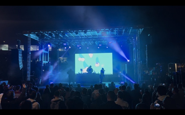 A concert stage with professional lighting, video, and audio set up for a corporate event.