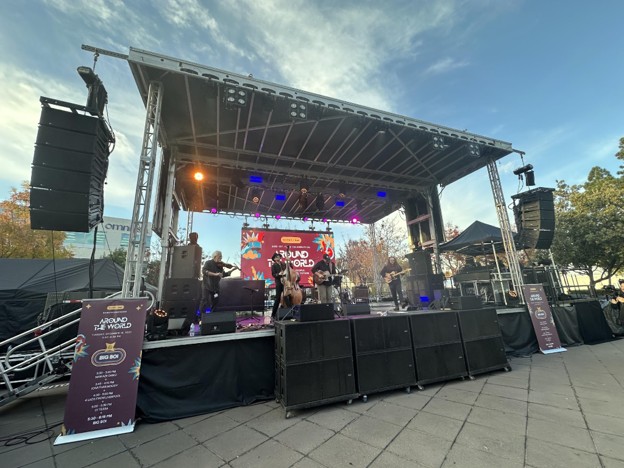 A live music stage with a band playing instruments and professional AV set ups.