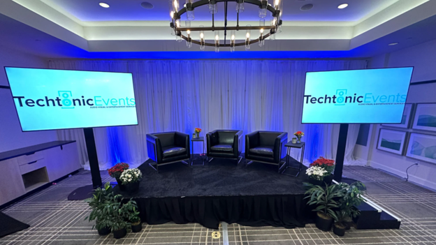 A small panel stage with “fireside chat” style seating and screens that showcase the Techtonic Events logo.