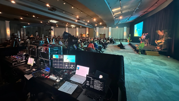 Behind the scenes of a tech table hidden by a tech drape at a corporate event.